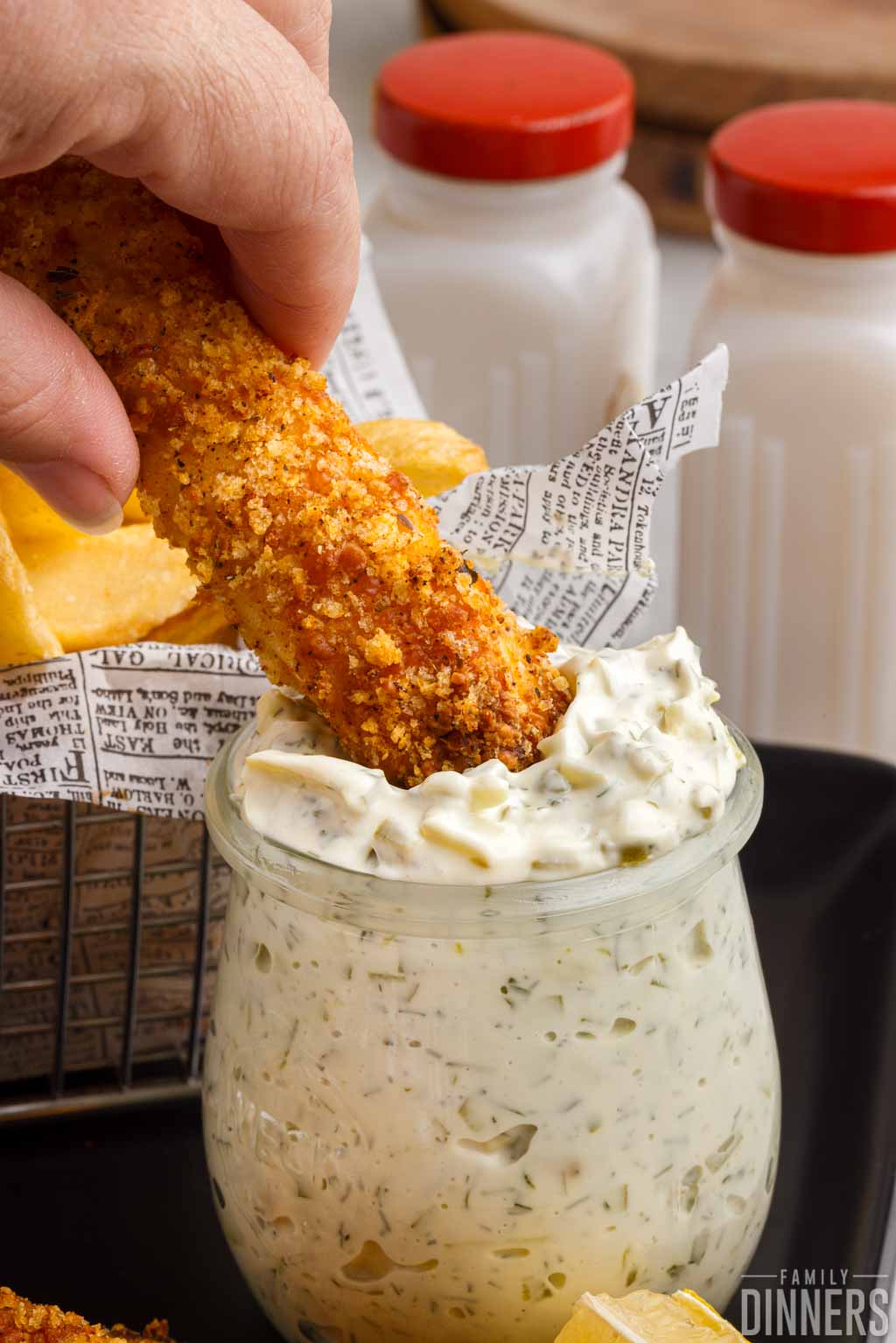 fried fish being dipped into tartar sauce