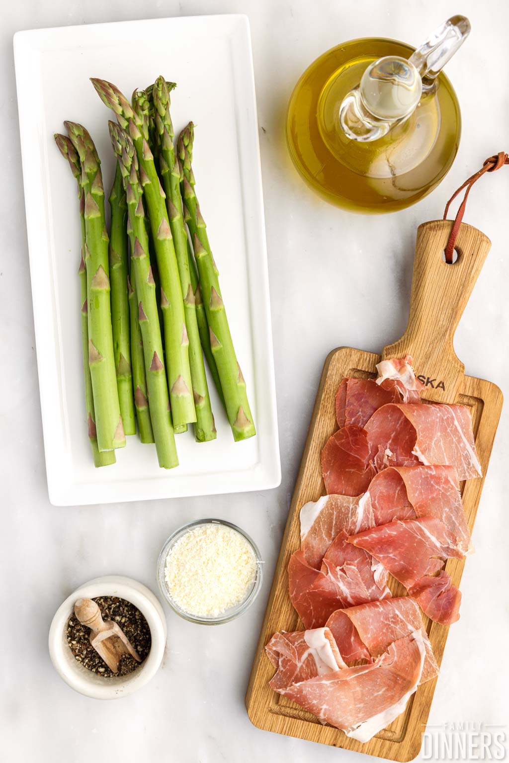 cut pieces of prosciutto next to plate of fresh asparagus