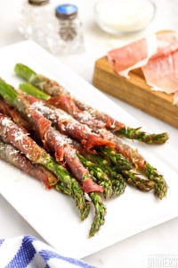cooked prosciutto wrapped asparagus spears sprinkled with parmesan cheese