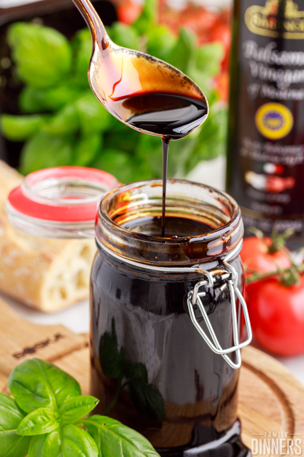 spoon drizzling balsamic glaze into a full jar of it