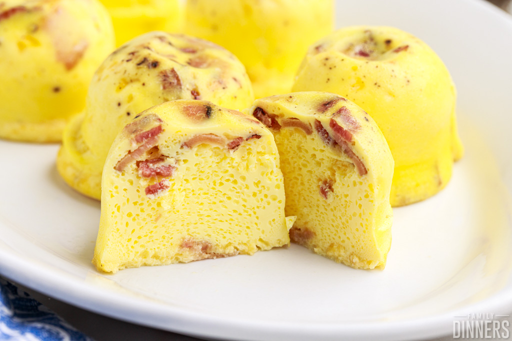 Cut open yellow egg bites with bacon bits inside.