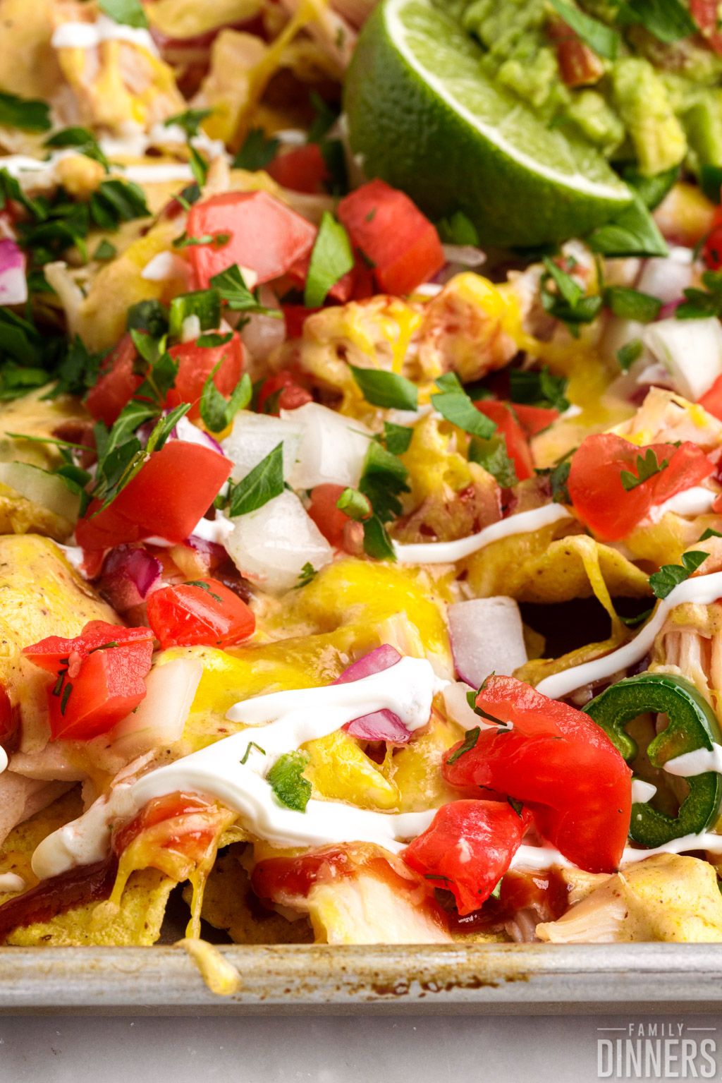 BBQ chicken nachos with chicken, cheese, sour cream, barbecue sauce and lots of toppings.