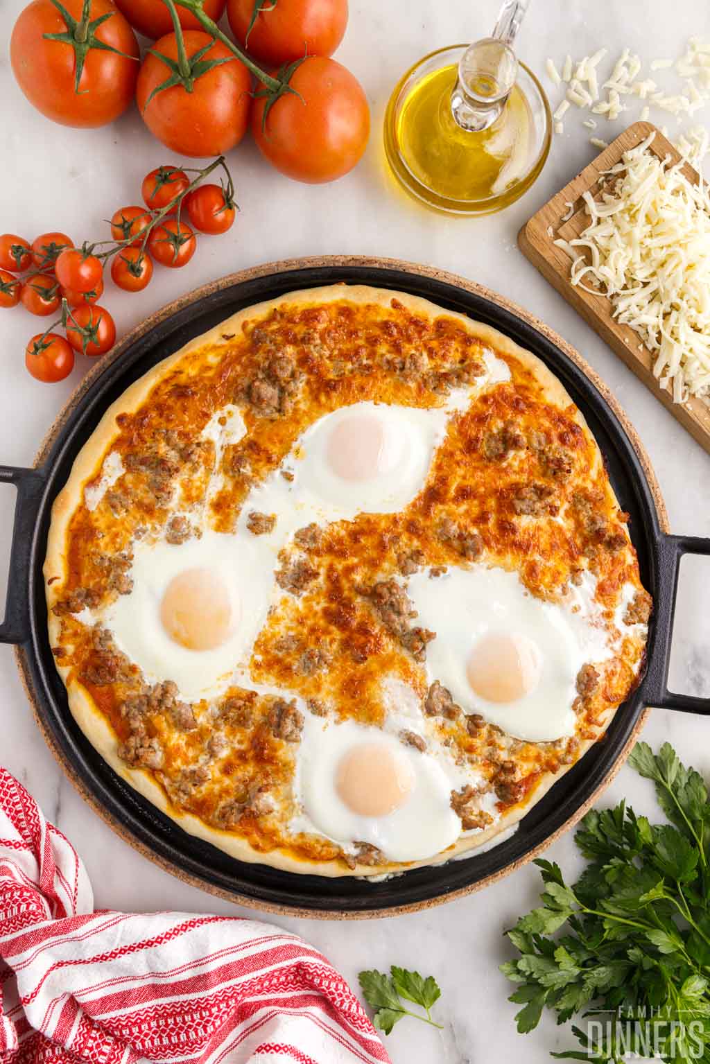 Cooked sunny side up eggs on sausage breakfast pizza.