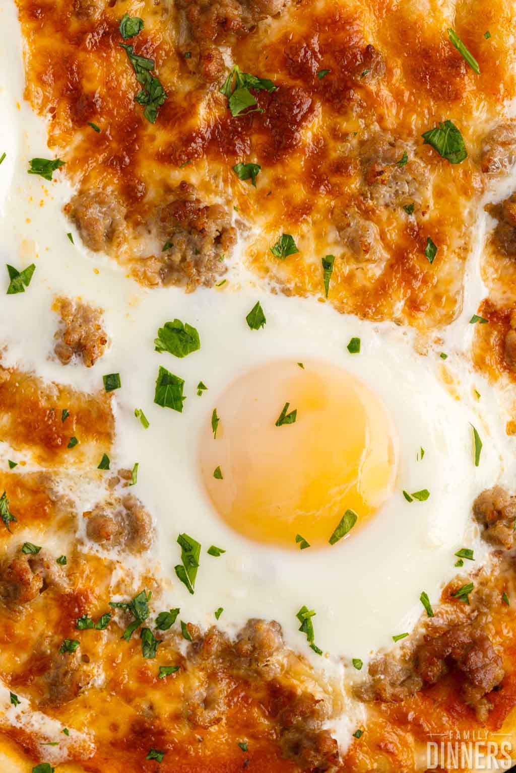 close up of egg on breakfast pizza.