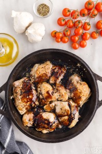 Balsamic glaze poured over chicken in a skillet.