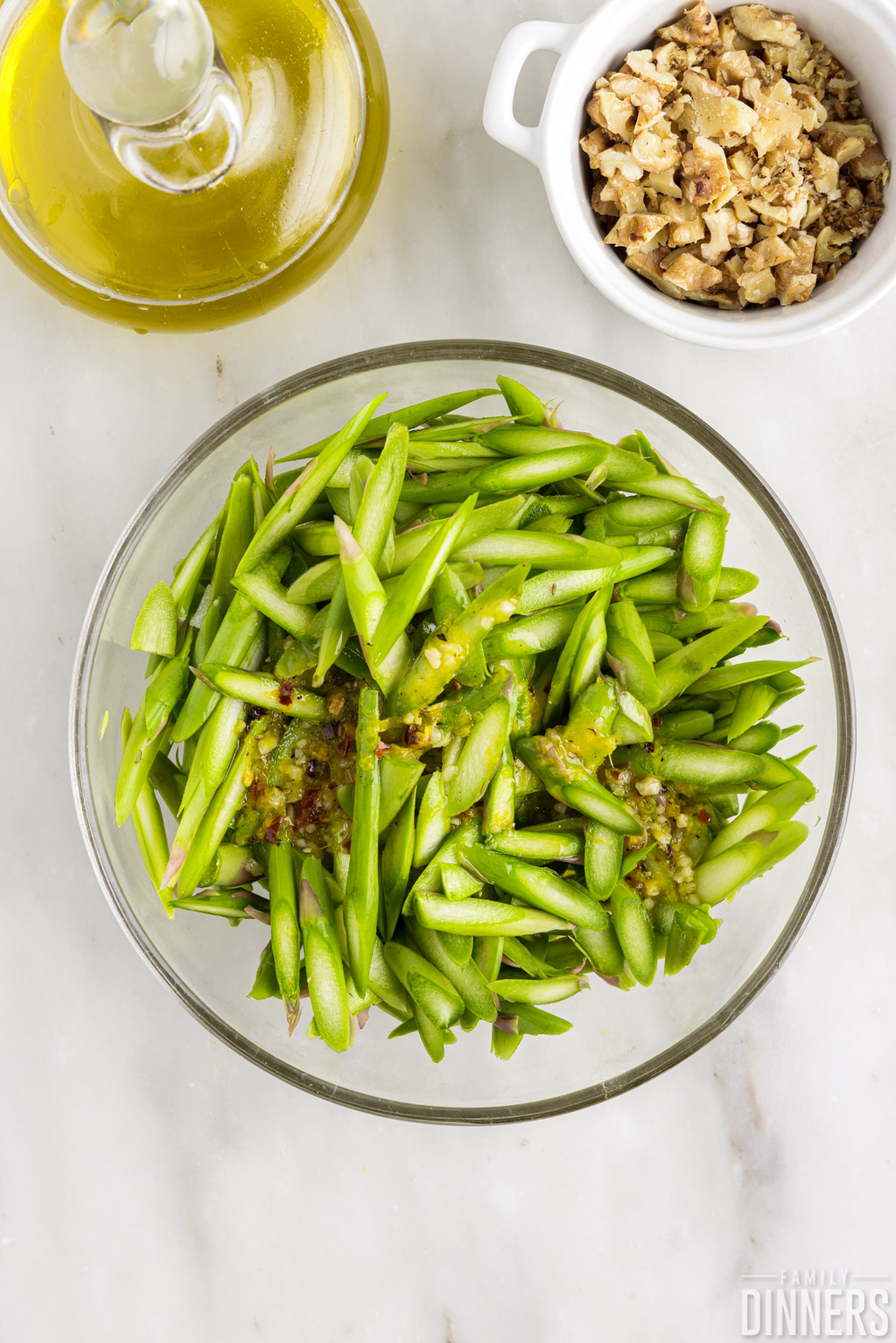 Dressing on asparagus in bowl.