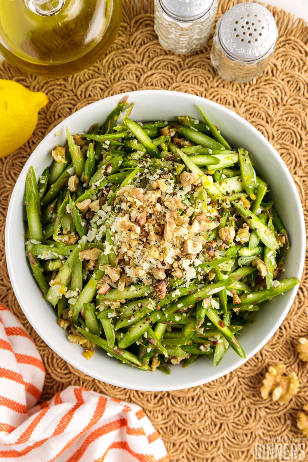 Raw asparagus salad with cheese and walnuts on top.