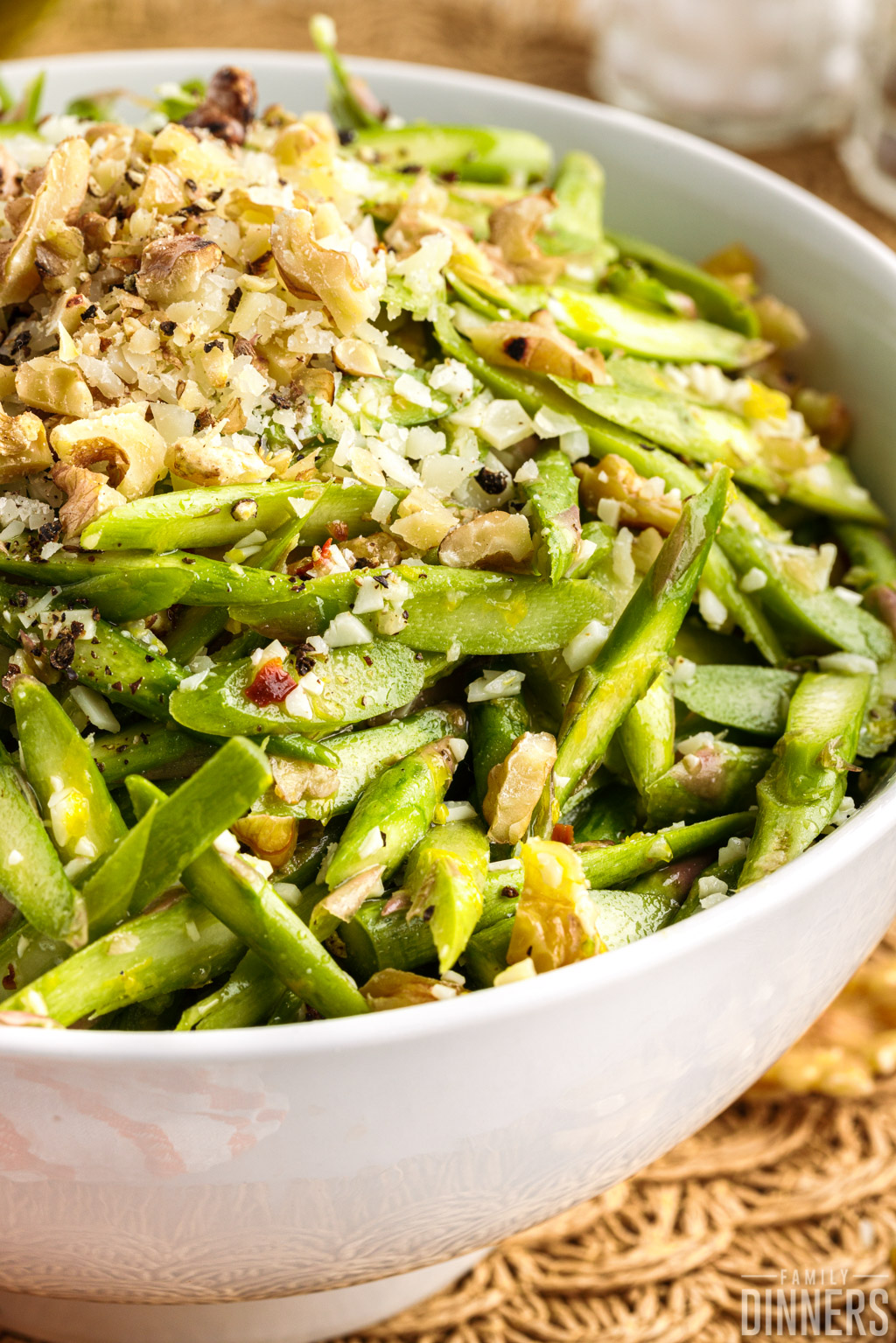 Raw asparagus salad with walnuts and parmesan cheese on top.