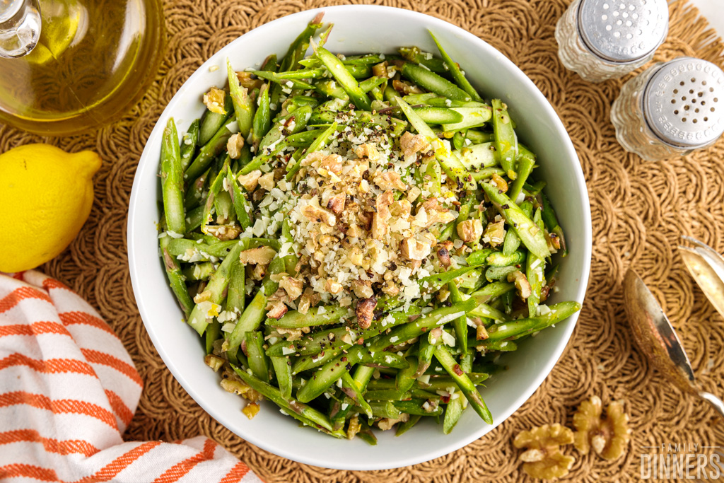 Overhead view of raw asparagus salad with walnuts.