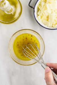 Dressing ingredients being whisked in a bowl.