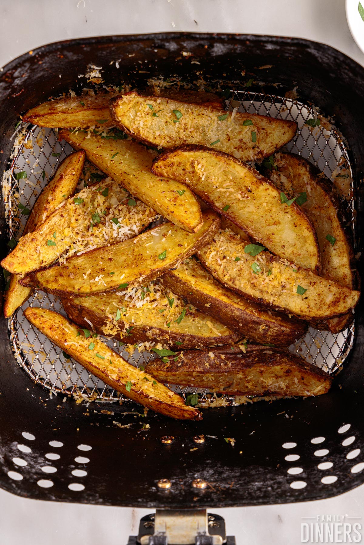 Air fryer potato wedges tossed with cheese.