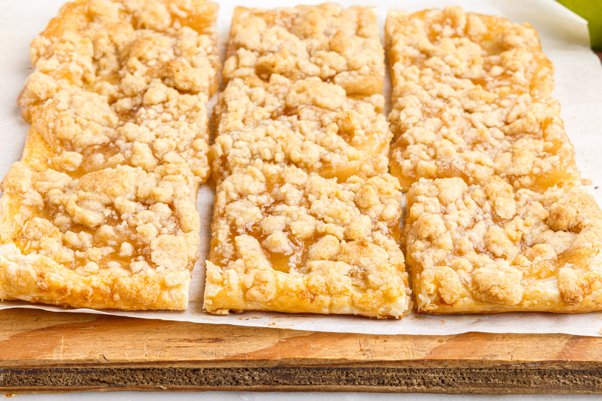 cut up apple pie bars on a wooden cutting board
