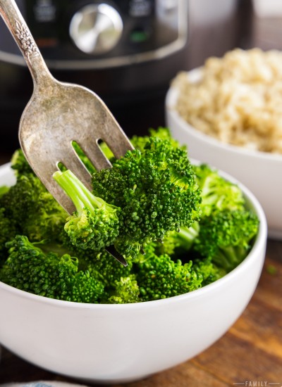 fork stabbing Instant Pot broccoli in a bowl