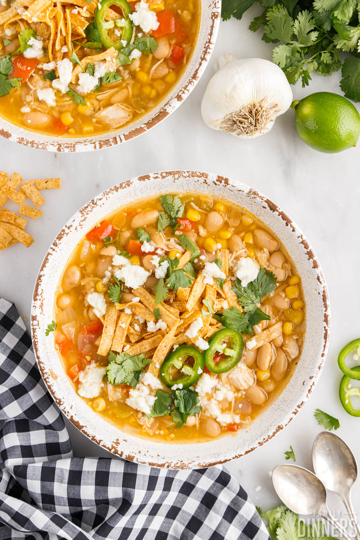two bowls of Instant Pot white chicken chili with garnishes