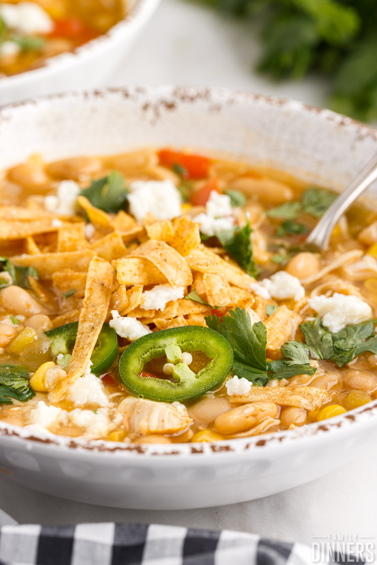 bowl of white chicken chili with a spoon in it