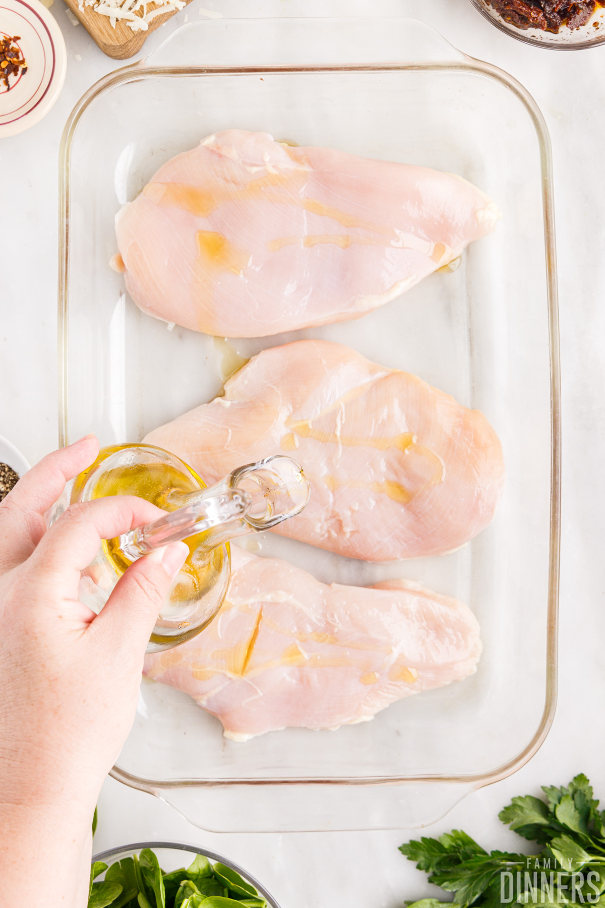rubbing oil on chicken breasts