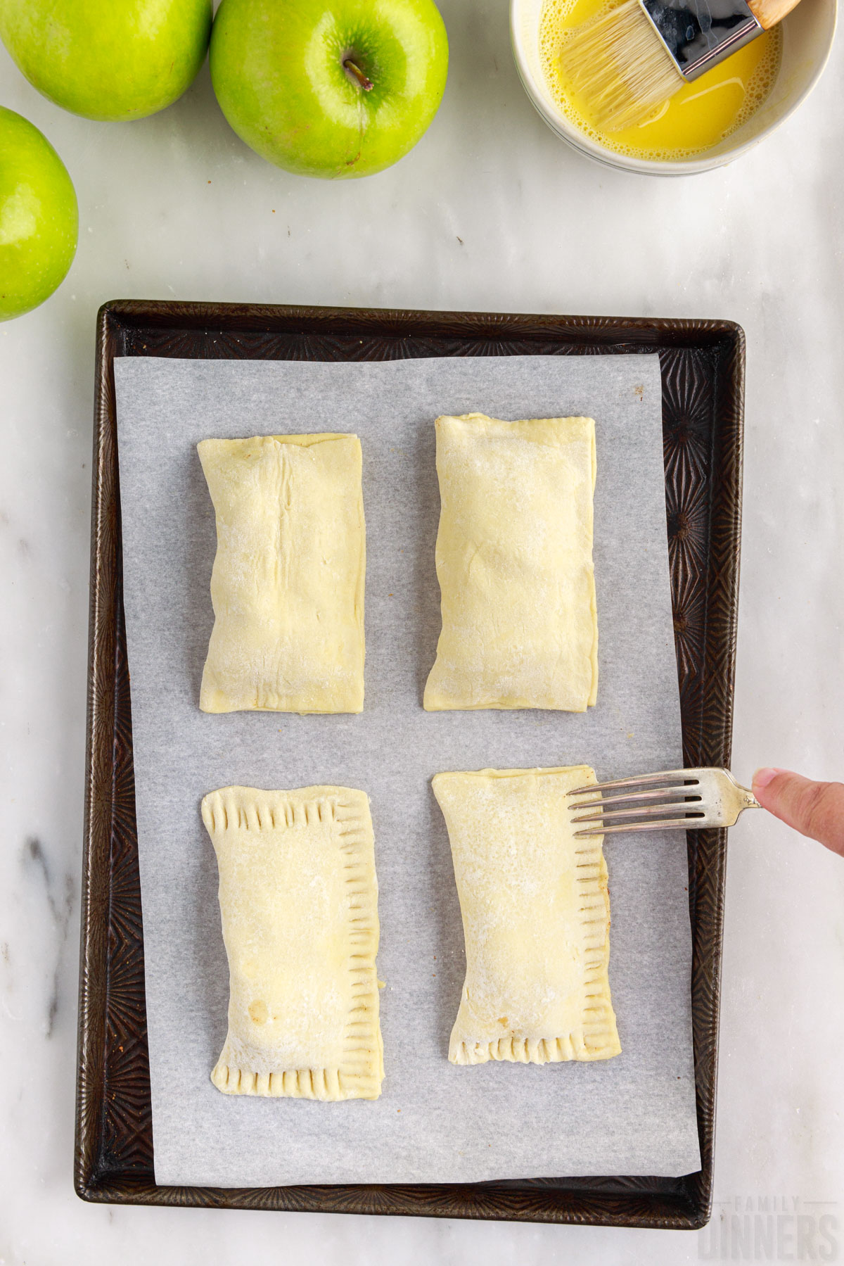 sealing handmade apple turnovers with a fork