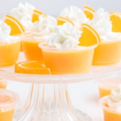 orange jello shots on a cake stand