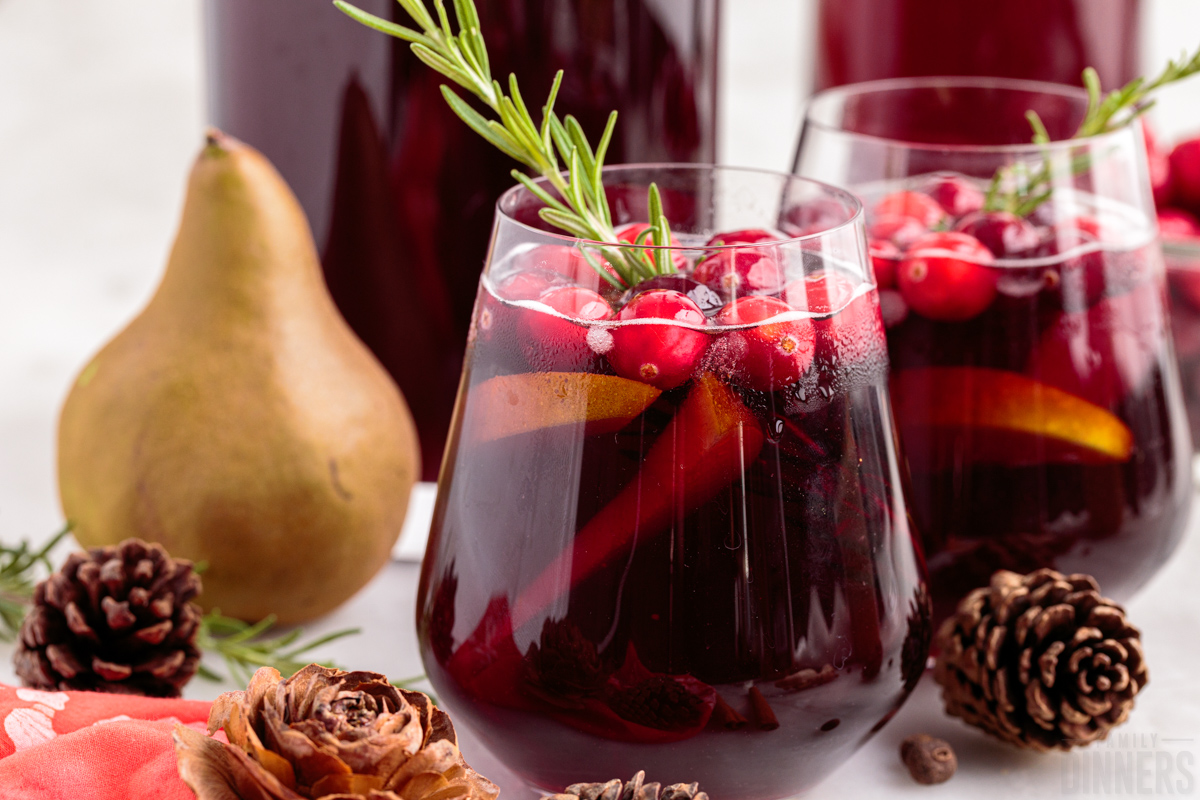 two glasses of christmas sangria with a pear