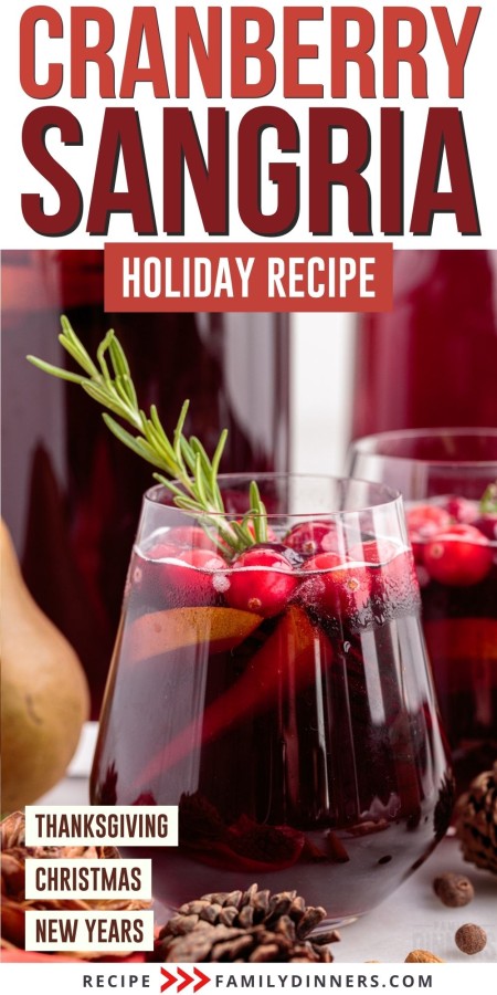 Glass of cranberry sangria with rosemary in it.