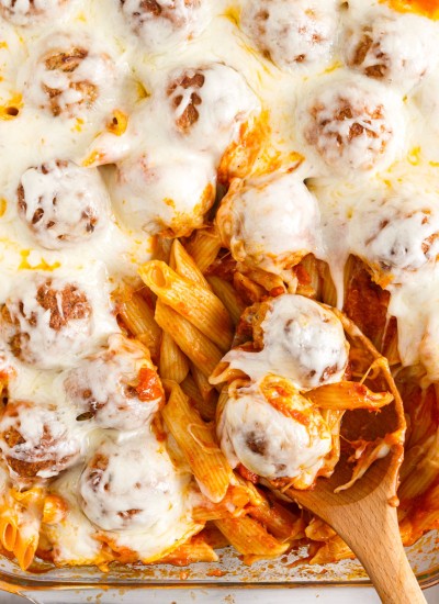 Dump and bake meatball pasta bake with serving spoon scooping out a bite.