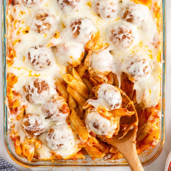 Dump and bake meatball pasta bake with serving spoon scooping out a bite.