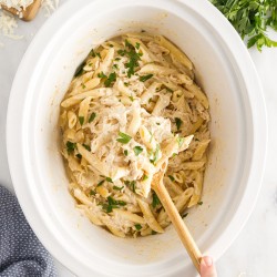 wooden spoon scooping crockpot olive garden chicken pasta