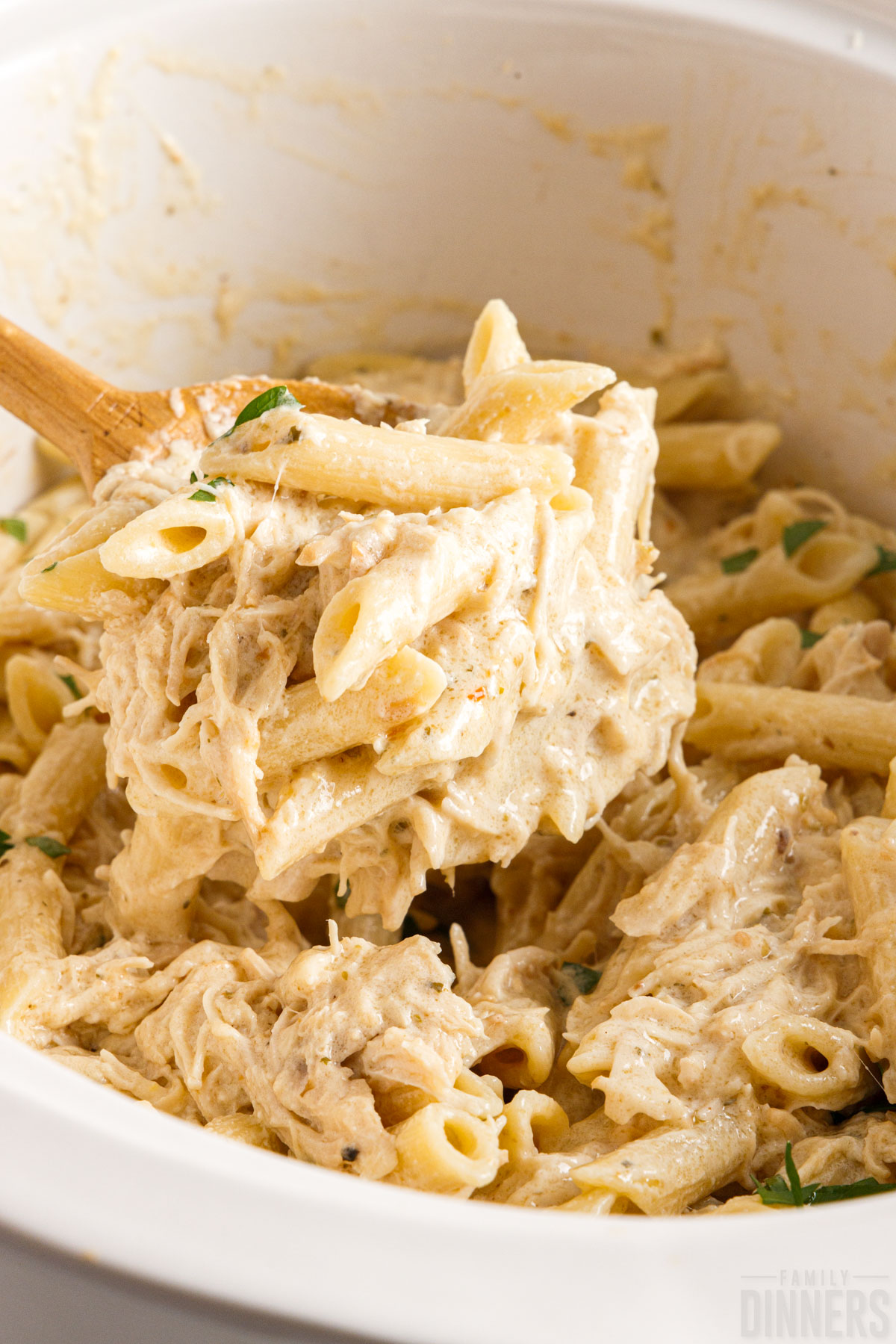 spoon scooping crockpot chicken pasta