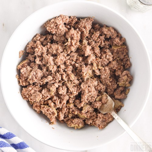 close up of cooked ground beef in a bowl with a spoon