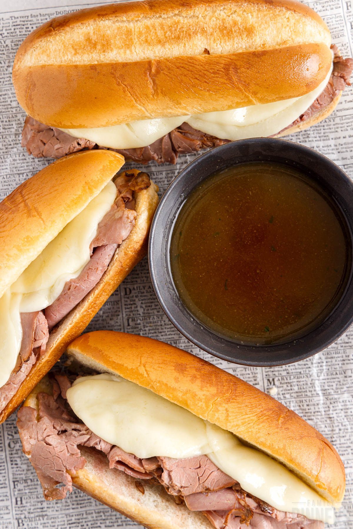 French dip sandwiches next to a bowl of prepared au jus dip