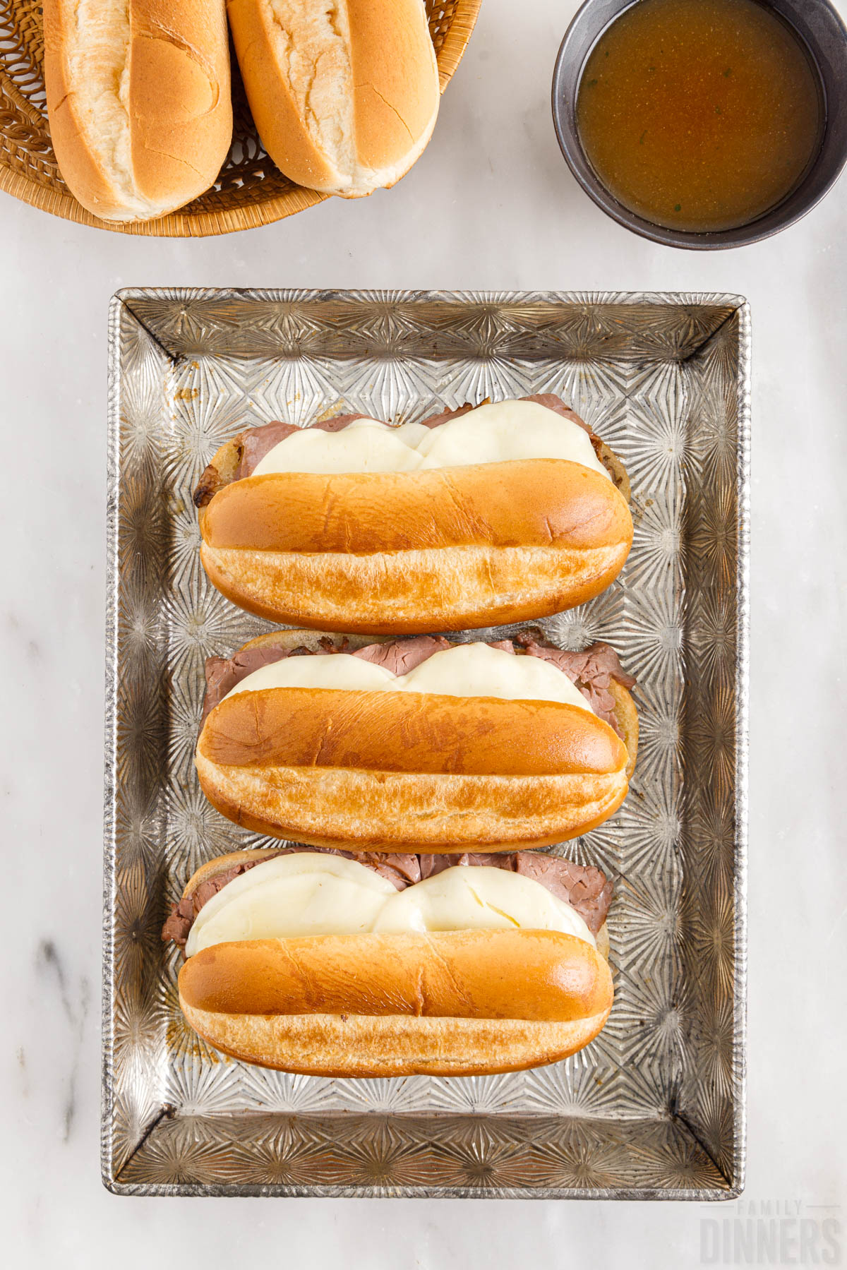 baked french dip sandwiches in a baking dish
