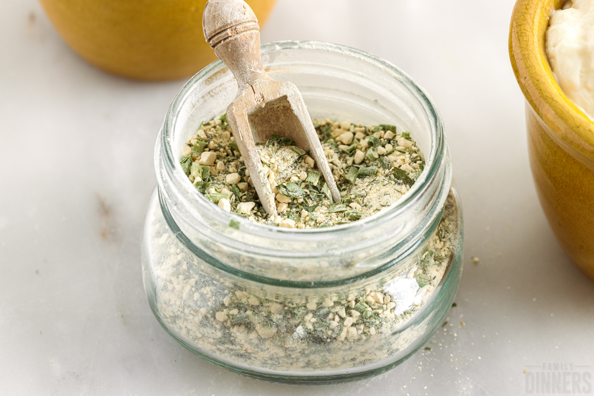 glass jar full of ranch seasoning with a wooden spoon