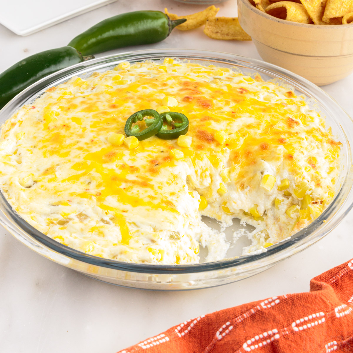 crack corn dip in a glass pie plate with some taken out of it