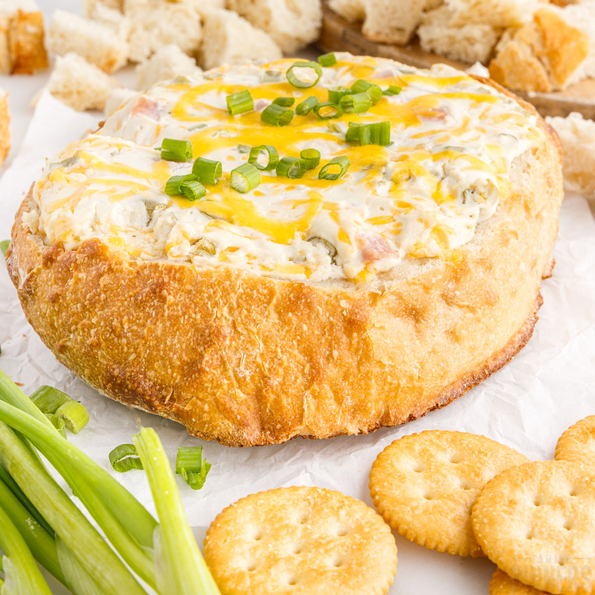 hot mississippi sin dip in a bread bowl with crackers and bread pieces