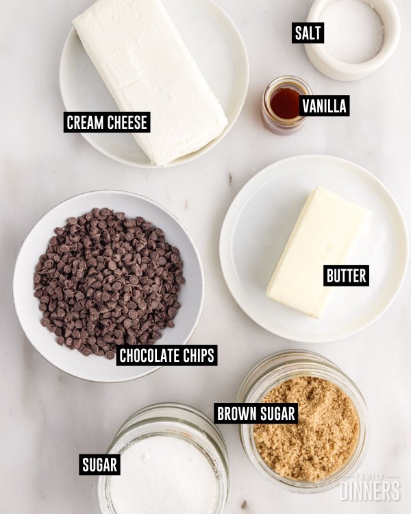 Ingredients in dishes. Cream cheese, salt, vanilla, butter, sugar, brown sugar and chocolate chips.
