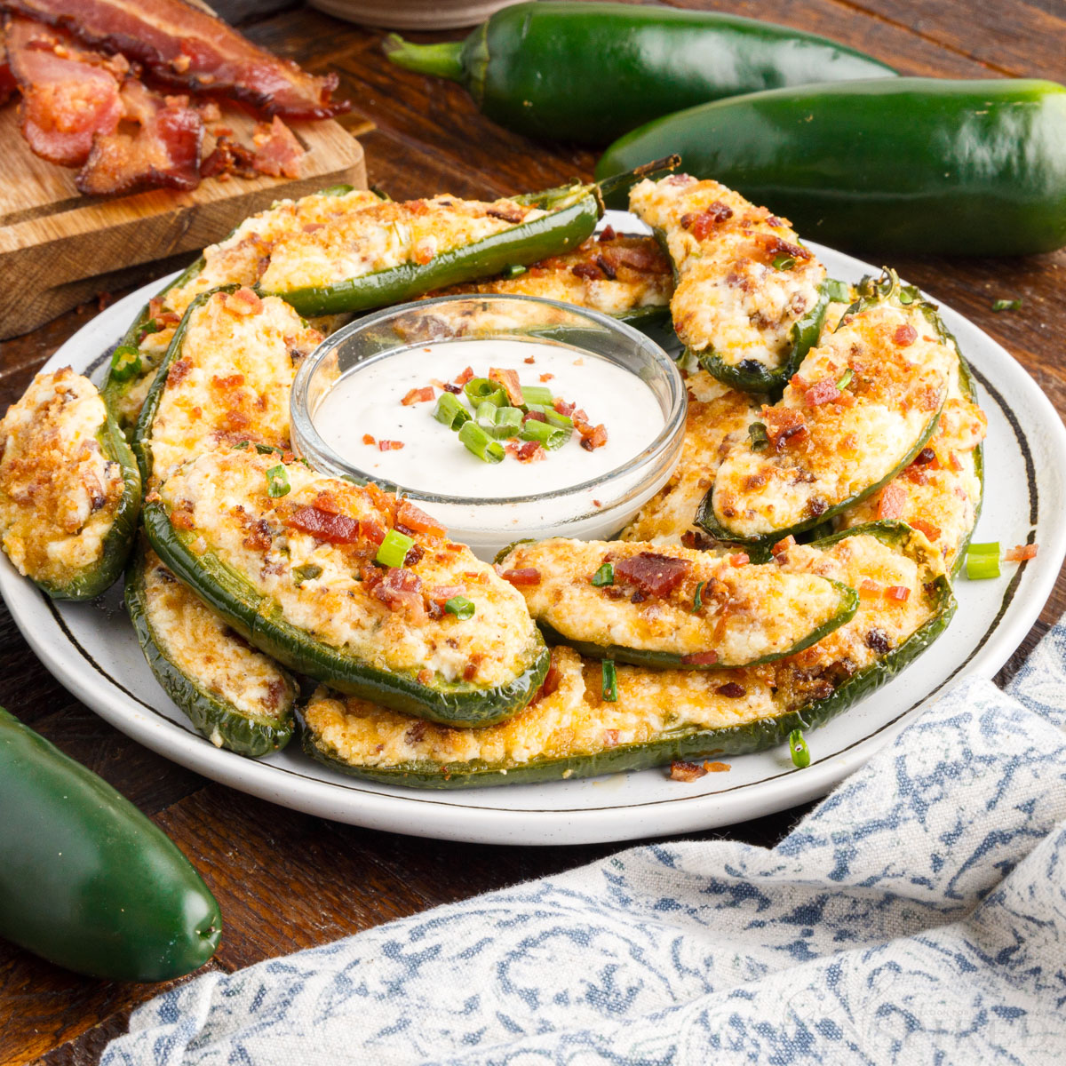 air fryer jalapeno poppers on a plate with a bowl of dip in the middle