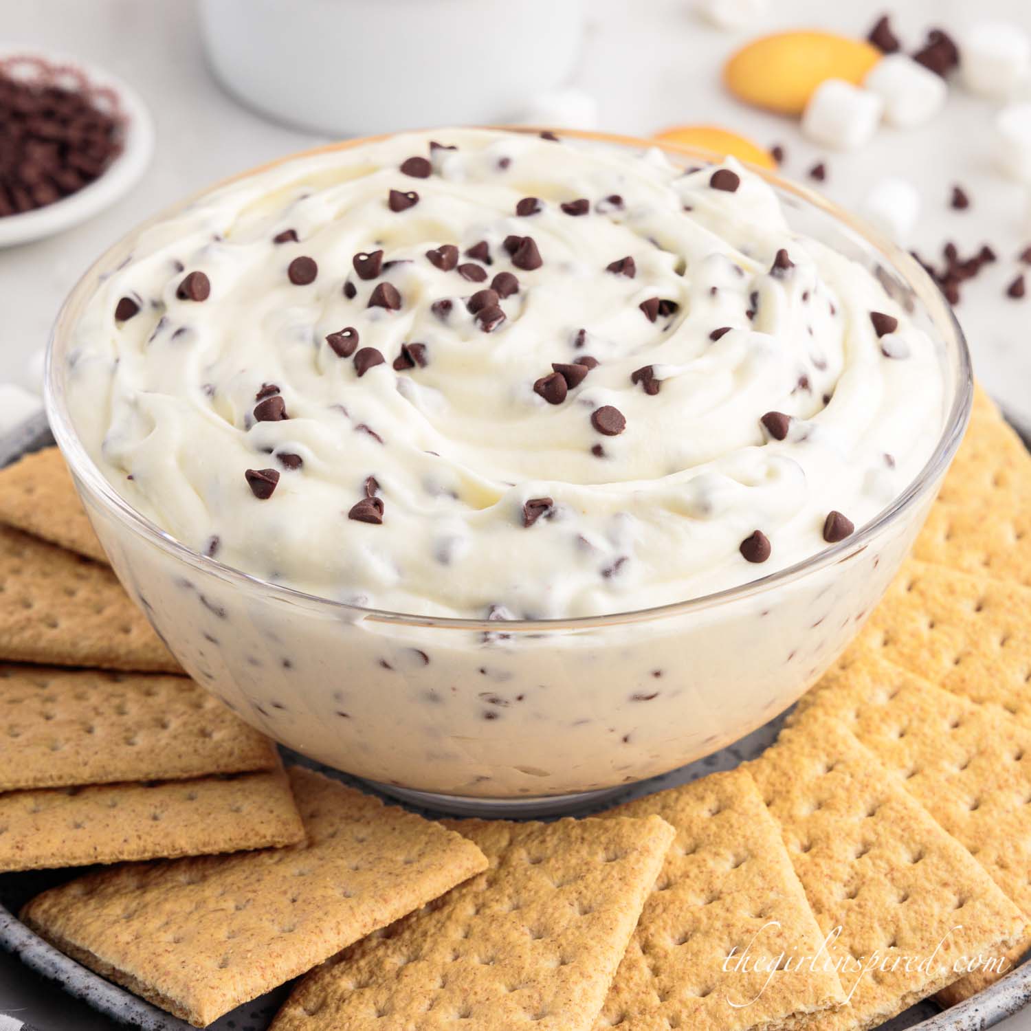 glass bowl full of booty dip, topped with chocolate chips and surrounded with graham crackers