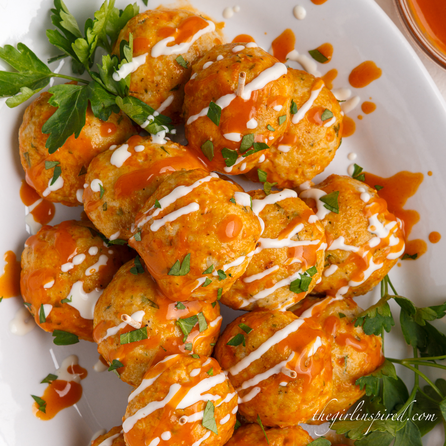 garnished buffalo chicken meatballs  on a plate, a crowd pleasing game day appetizer