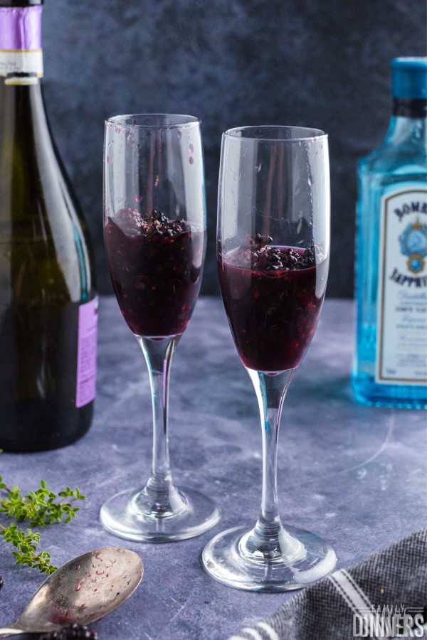 gin, simple syrup and blackberries in champagne glasses